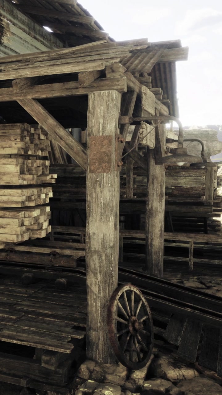 Struttura in legno in una segheria con pile di legname e vecchi binari