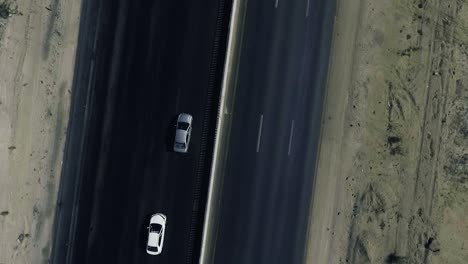 a slow mo aerial top view of two cars moving on a highway in northern areas