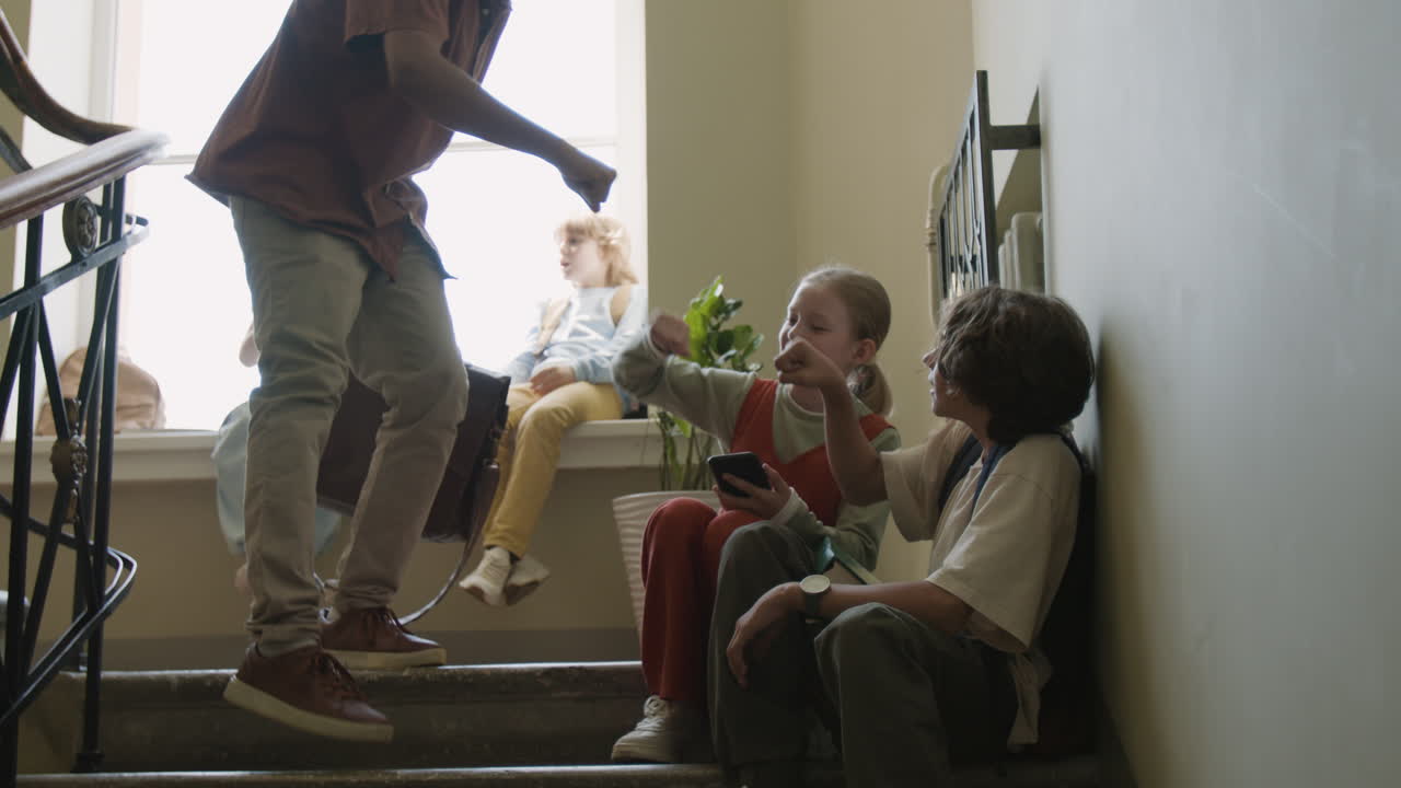 Students and teacher interacting in a school hallway during break time