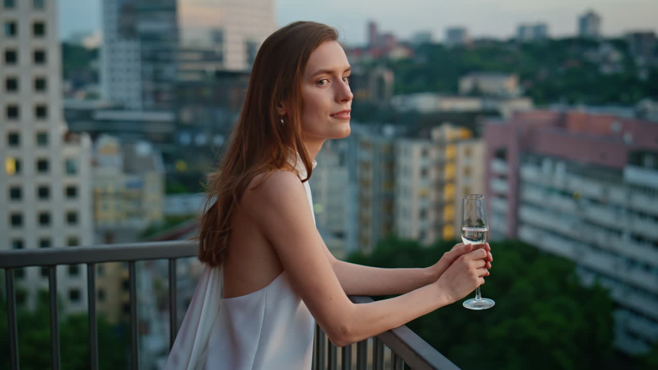 Elegant dressed woman standing on balcony enjoying peaceful evening closeup