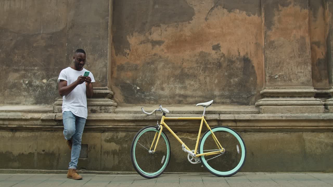 Uomo con bicicletta che usa il telefono
