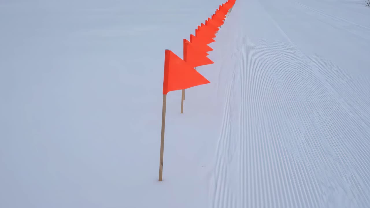 Oranssien lippujen merkitsemä polku tuoreessa lumessa