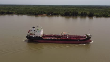 drone flight next to a large oil tanker sailing the amazon river