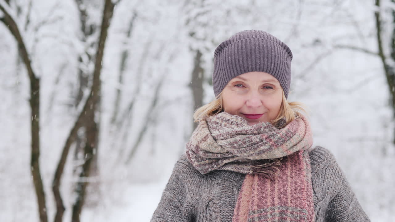 retrato de una mujer con un suéter cálido y una bufanda sobre el fondo de un invierno cubierto de nieve