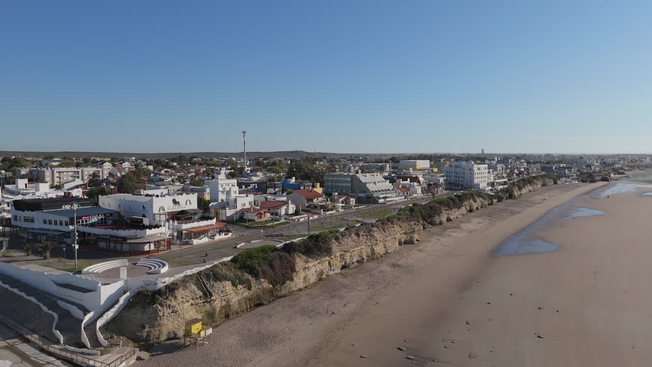 Aerial view of coastal city shore, beach, buildings, no people. Argentina Las Grutas