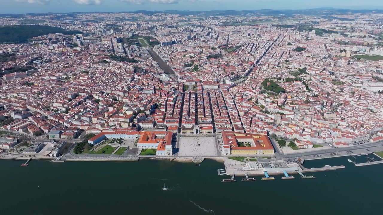 Ripresa panoramica ad alta quota con drone di Lisbona a mezzogiorno. Piazza del Commercio centrale. Tetti rossi, fiume Tago, cielo azzurro limpido