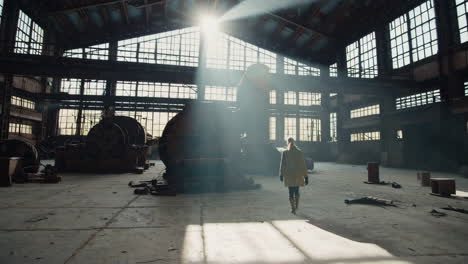 woman walking through an abandoned factory