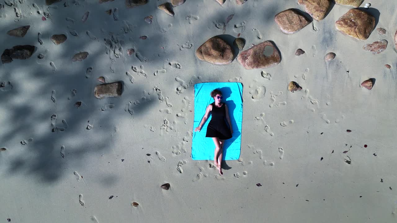 여자는 해변에 누워 섬에서 외로운 꿈을 꾸고 있습니다.