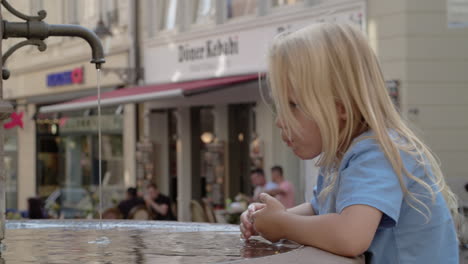 young girl drinking from city fountain in baden-baden