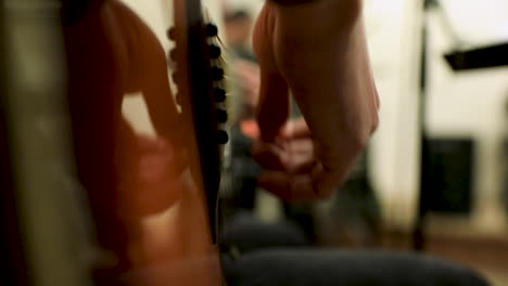a male hand playing the guitar in the studio - close up