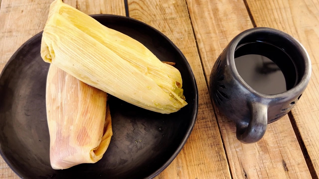 Tamales e caffè su un tavolo rustico, che evocano calore e tradizione.