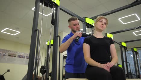physiotherapist providing massage therapy to a patient in a gym setting