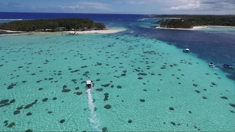 extravagant island of mauritius with a tourist speed boat sailing on the crystal clear coral reef waters