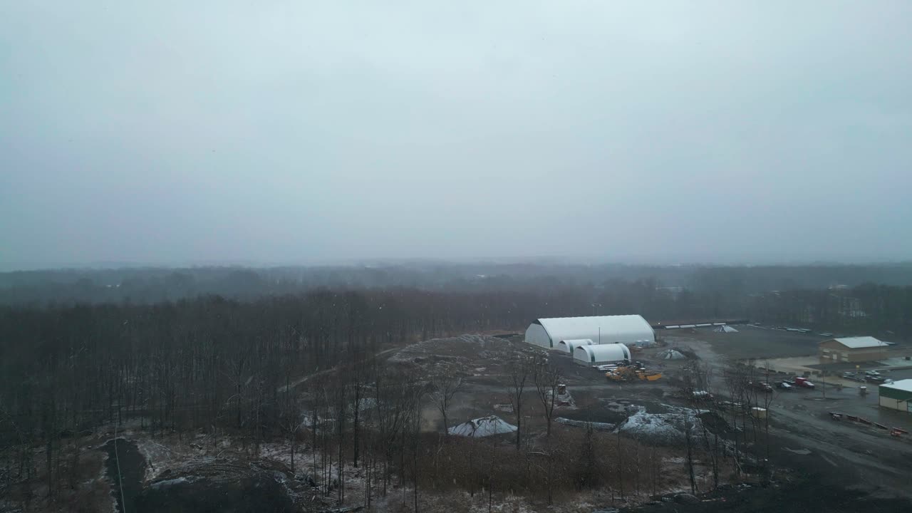 雪嵐が押し寄せる中の住宅街の空撮