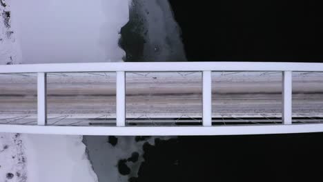 cinematic birds eye view, ascending aerial of empty bridge and snowy winter landscape, sweden