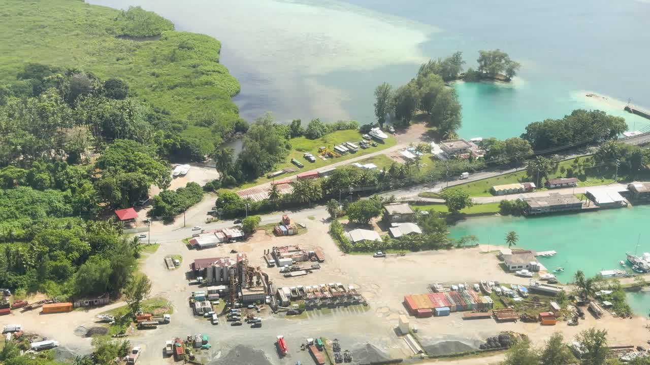 Korkeakulmainen ilmakuva dronella panoroituu trooppisen rannikkokaupungin ja sillan yli Palaulla.