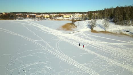 Two-people-walking-on-a-frozen-lake-on-a-cold-sunny-day