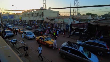 timelapse high angle view of busy serekunda market street bustling with people and traffic
