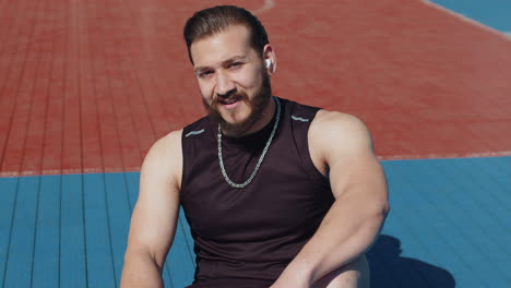 portrait of tired smiling athletic lebanese man in sportswear relaxing after playing basketball game