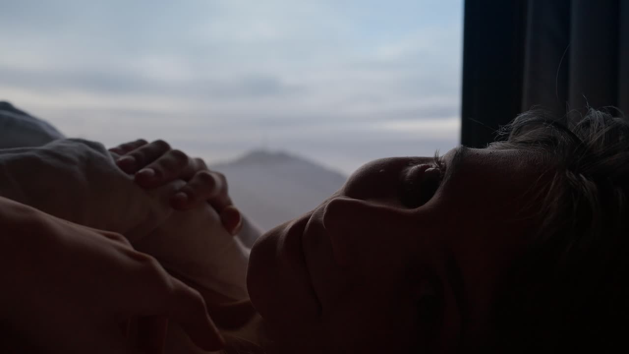 Woman Relaxing in Bed with Mountain View