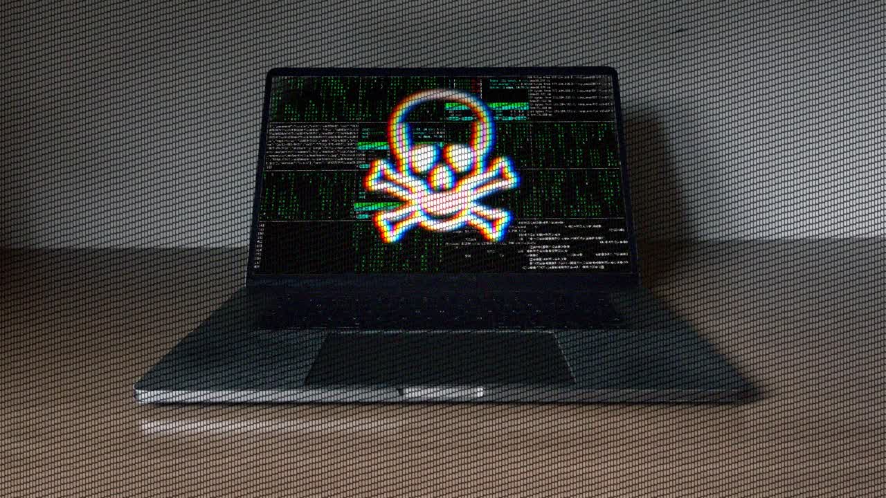 Laptop screen showing skull and crossbones with digital code in background