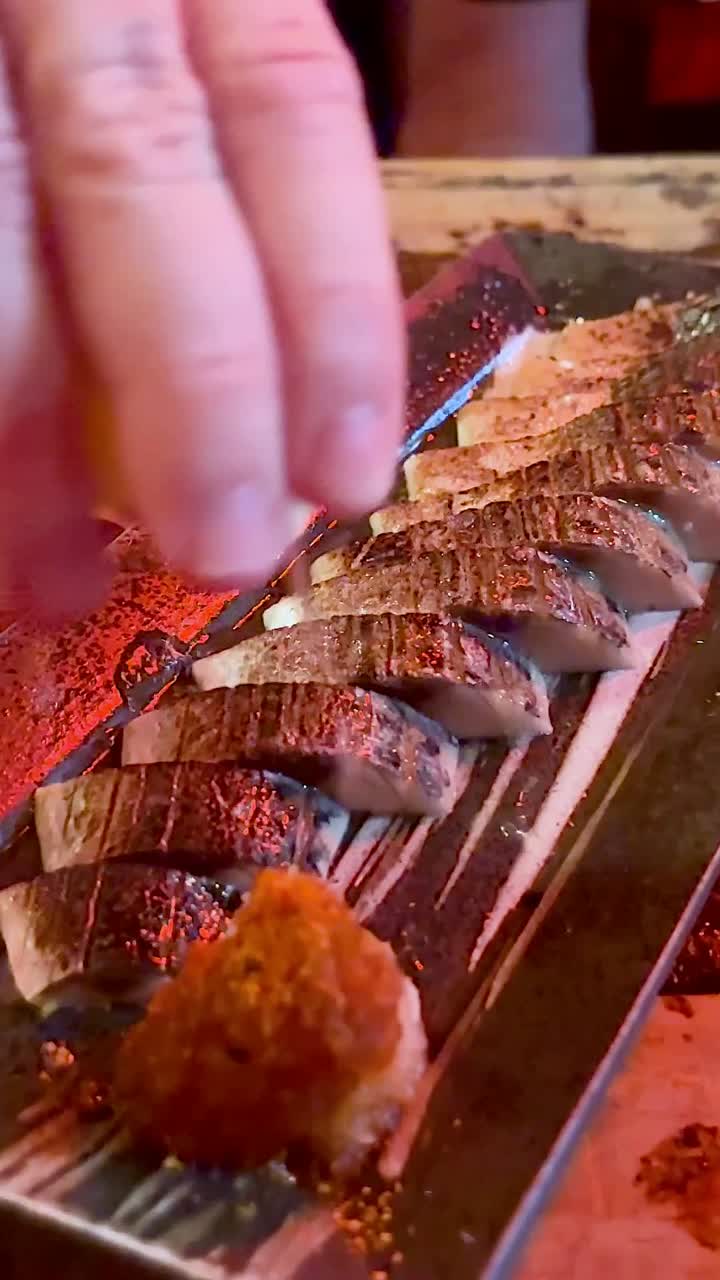 요리사는 극적인 불 효과로 수시를 준비합니다.