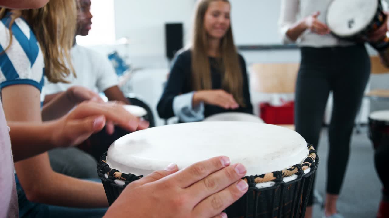 estudiantes adolescentes que estudian percusión en la clase de música