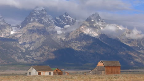 Eine-Alte-Scheune-Erhebt-Sich-Aus-Einer-Prärie-Mit-Den-Großen-Tetons-Im-Hintergrund-8