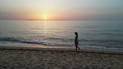 mujer adulta camina en la playa de arena durante la puesta de sol en cerdeña, italia - camión a la izquierda 4k