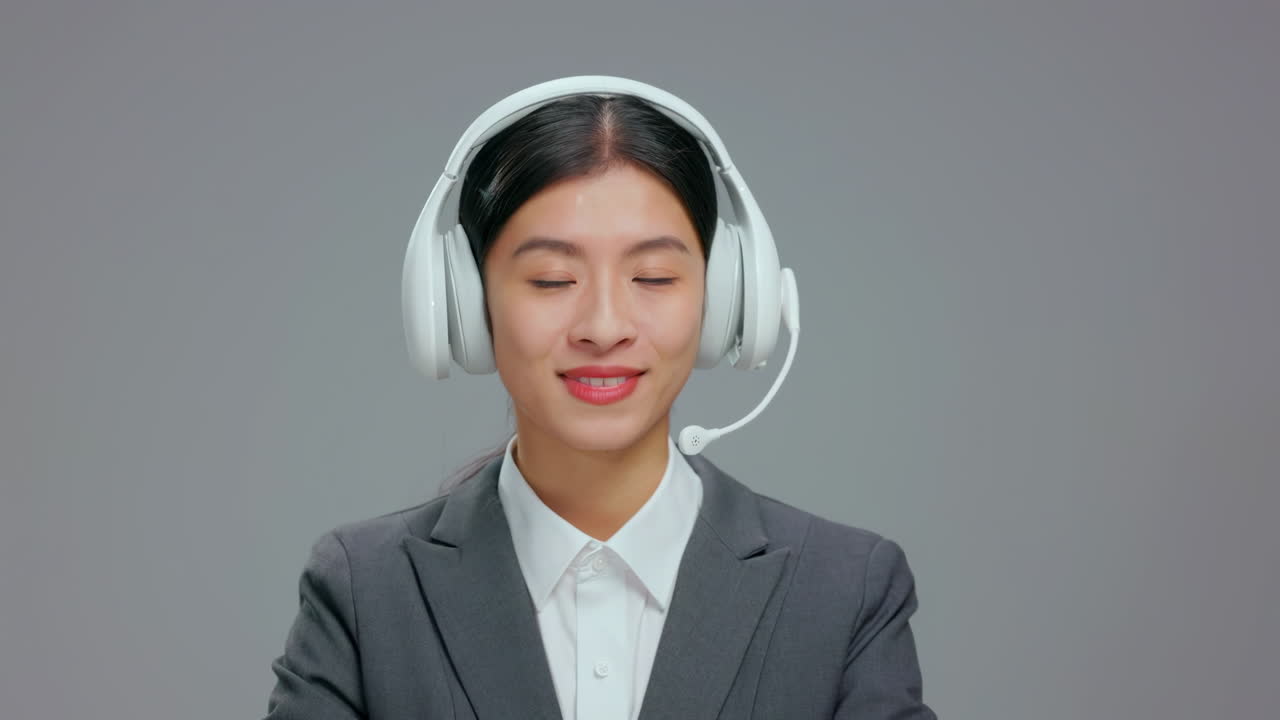 Smiling young business woman wearing headset, working in a call center, providing customer service, and communicating with clients in a professional office.
