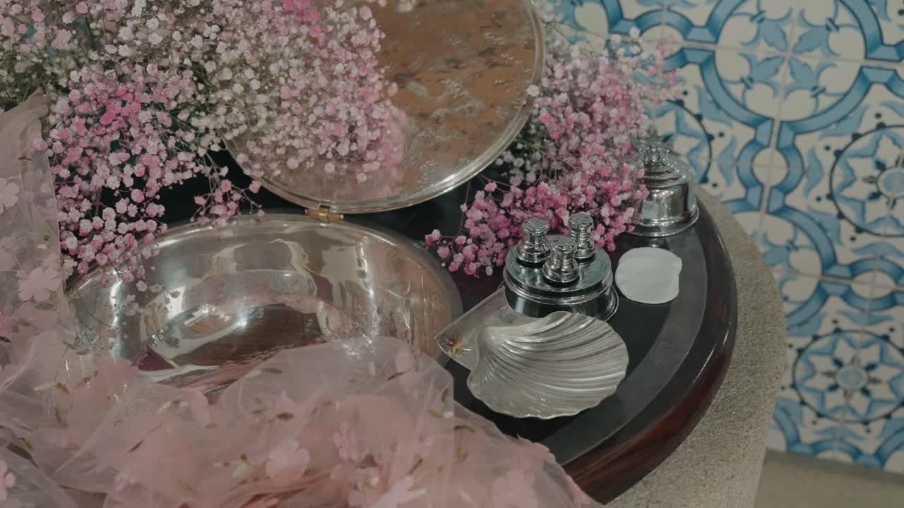 Silver baptism bowl with pink flowers on church table