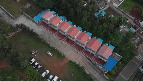 Aerial view of Identical twin colorful buildings in a peaceful green neighborhood in a remote natural environment