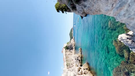 Dubrovnik-West-Harbour-next-to-Fort-Lovrijenac-on-a-beautiful-day-with-kayakers-and-yachts-in-the-distance,-Croatia