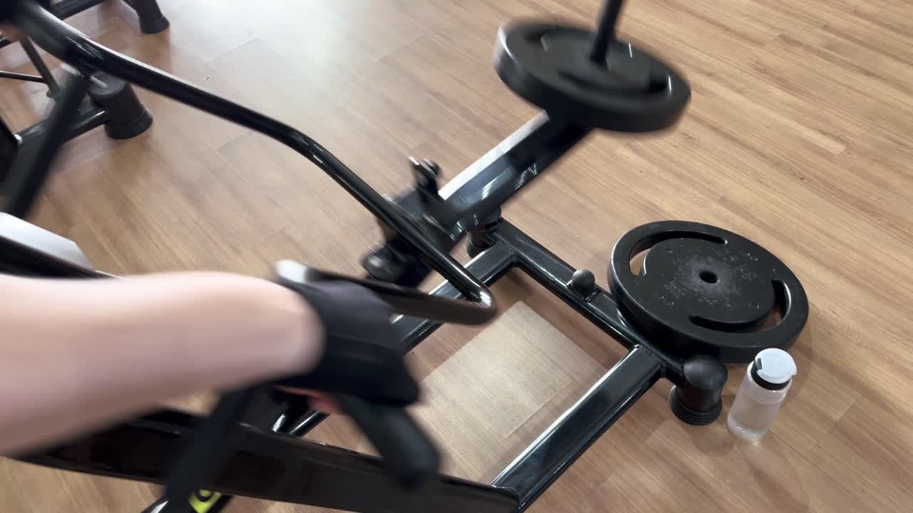 체육 장갑을 착용 한 소녀는 체육관에서 무게를 들어 올리고, 체육원에서 팔 근육을 개발하기 위해 덤벨을 들어 올리는 연습을합니다.