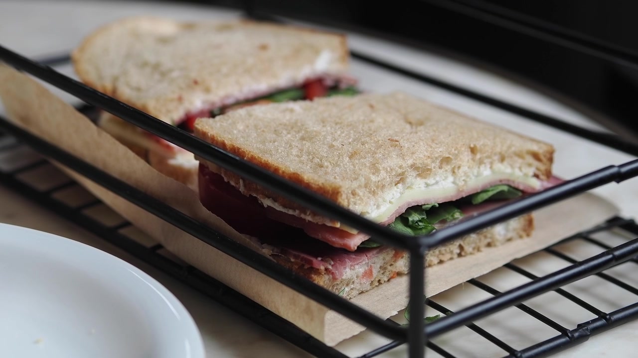 Heerlijke broodjes ham en kaas geserveerd op een draadrek