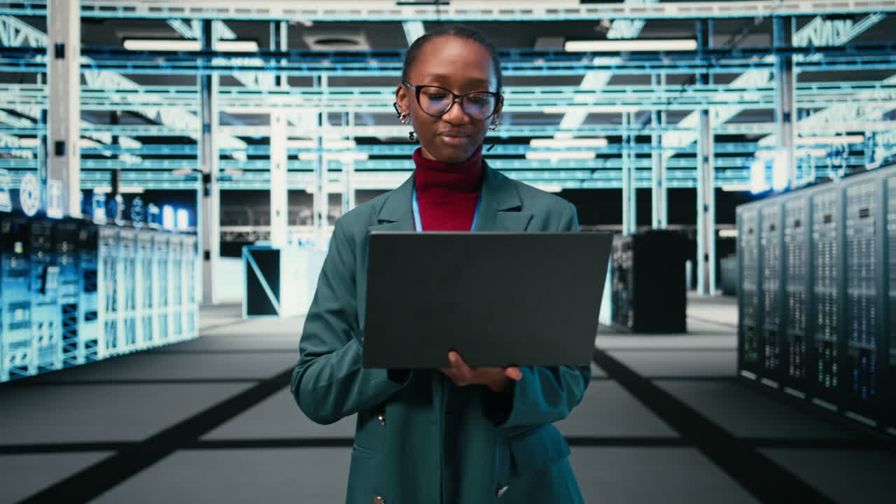 Ingegnere IT donna che lavora su un portatile in un data center