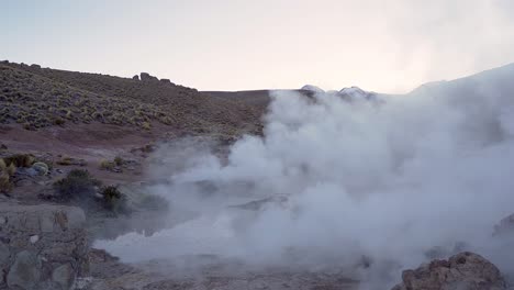 el tatio geysers steaming before sunrise in the atacama desert in chile, south america