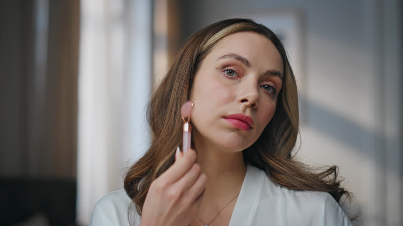 Woman using a face roller for skin care