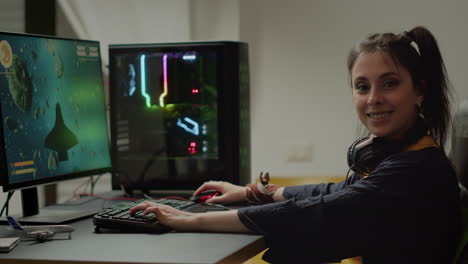 gamer looking at camera smiling, playing online space shooter video game