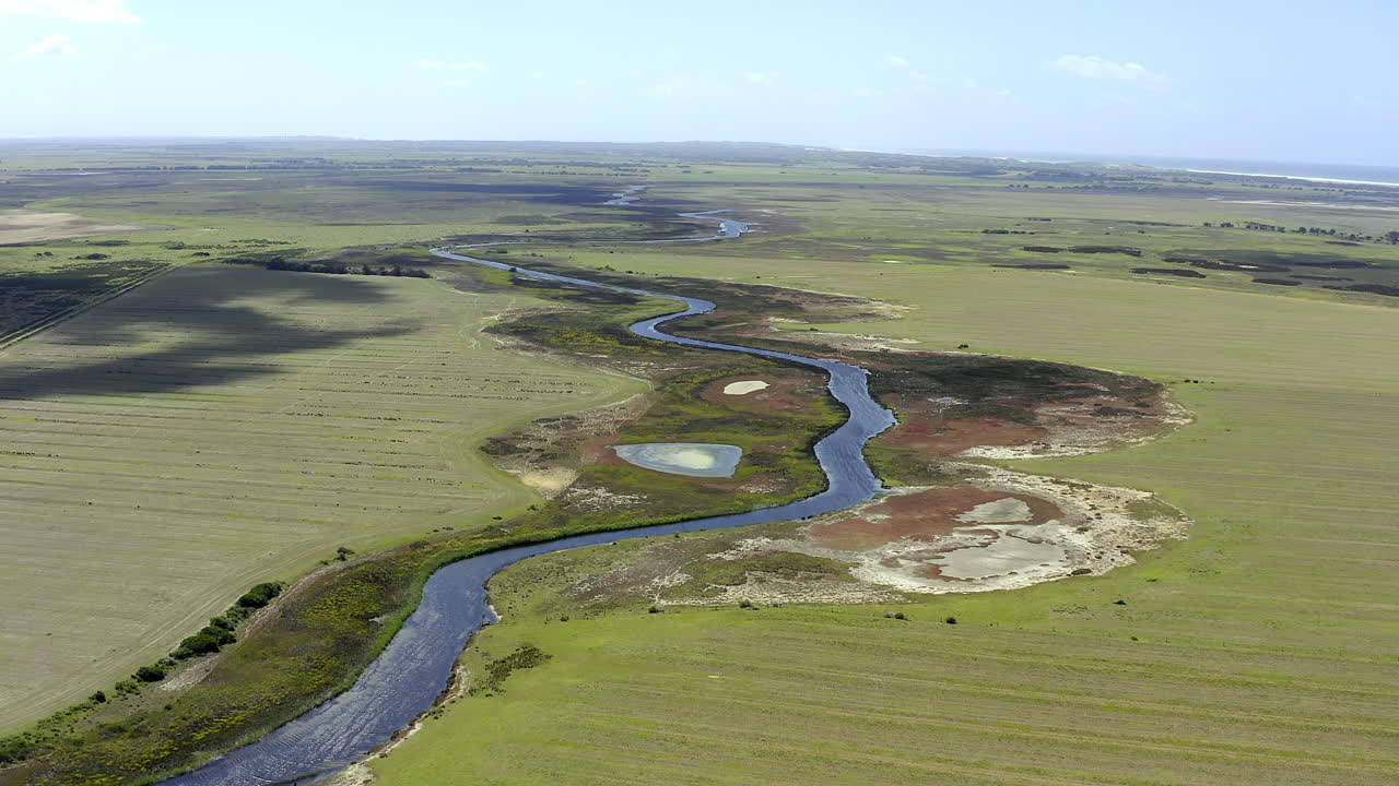 농경지 를 가로질러 휘어지는 강 의 공중 전망