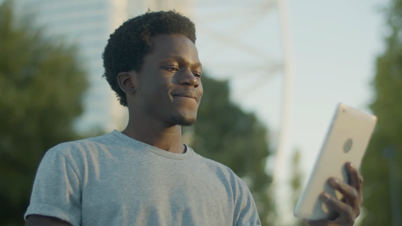 Closeup Shot Of Young Guy Having Video Chat And Sending Kiss On Tablet Outdoors