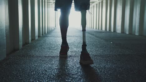 person with prosthetic leg walking through a tunnel