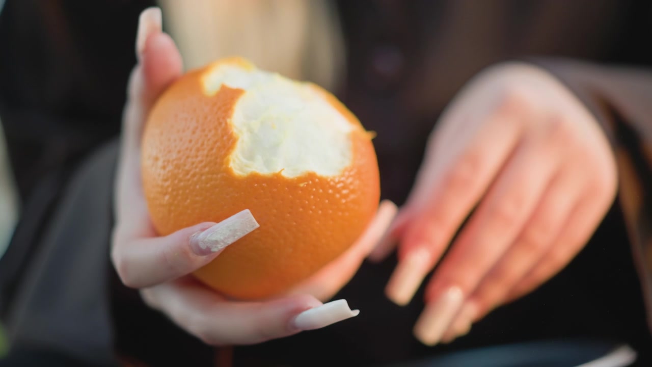 Close-up of Woman Peeling a Fresh Orange