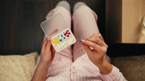 woman in pajamas taking medicine