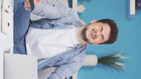 Vertical-video-of-Man-laughing-at-phone-message.