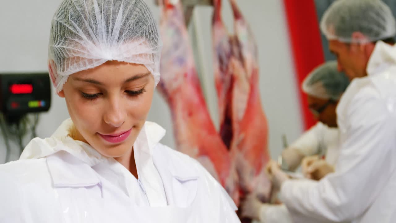 Female butcher using digital tablet