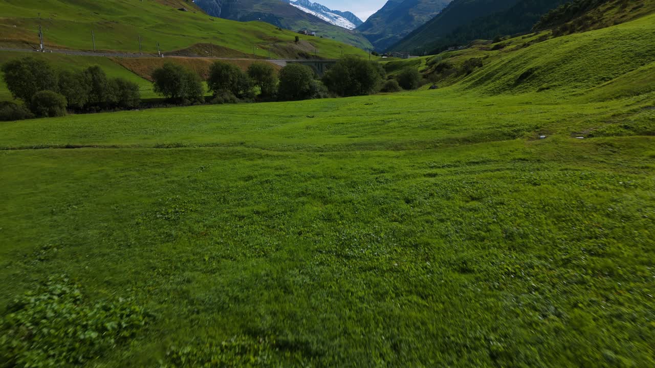 Drone che sorvola un prato verde del Passo della Furka in estate, Svizzera