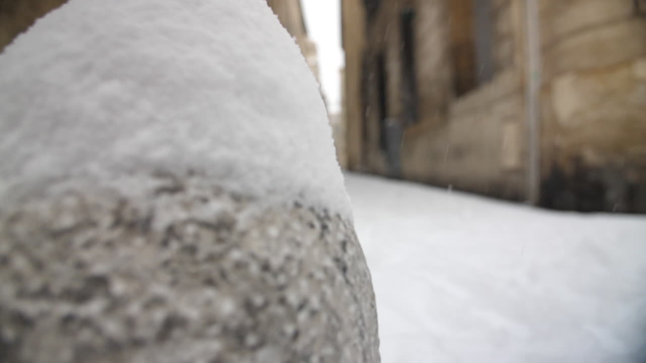 la nieve cae a cámara lenta en una calle de montpellier, francia. el invierno es frío y nevado.