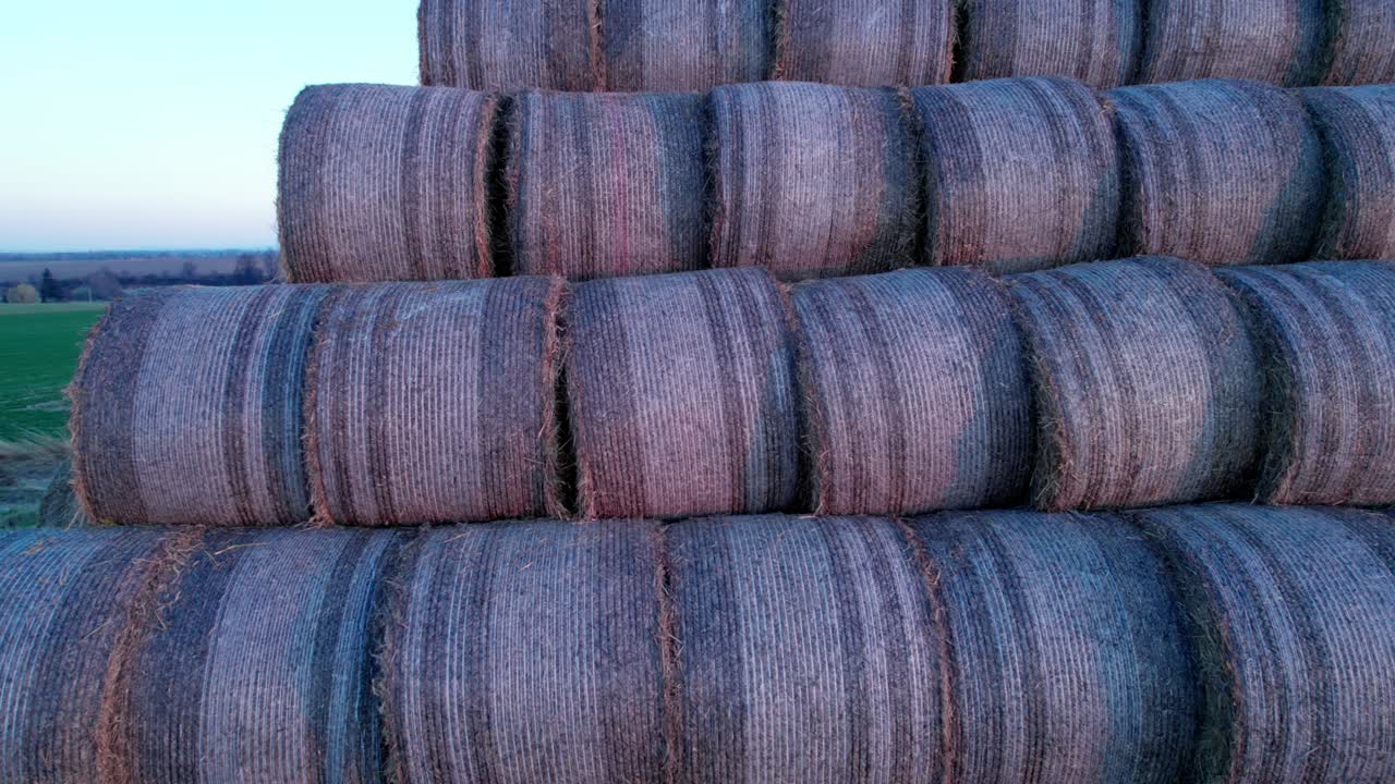 las balas de heno, apiladas en una pirámide, secas en el campo al atardecer.