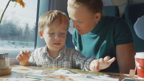 mother and son with childrens book in the train